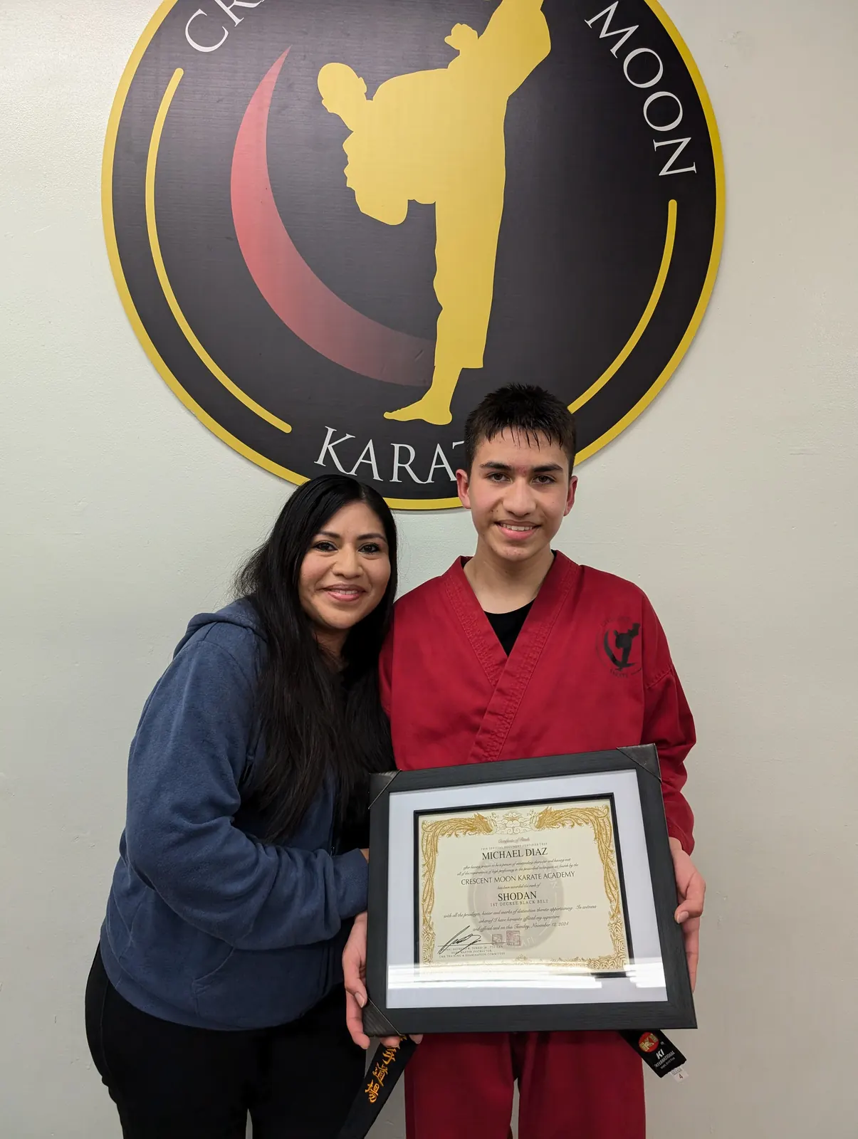 A student and parent hold a rank certificate